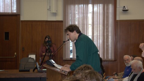 Chris Bissa, a neighbor who filed noise complaints against the brewpub, sat in the stands to listen to dozens of community members defend Libertine's new late night hours.