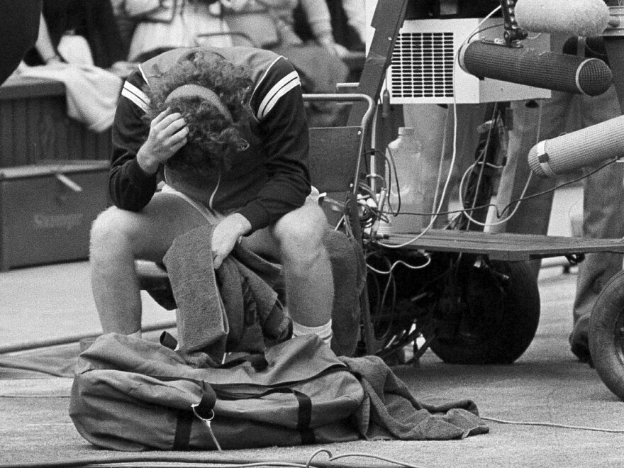 John McEnroe holds his head in his hands after being beaten by Sweden's Björn Borg.