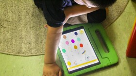 Juan, 7, is learning to use assistive technology on an iPad to communicate at his school, Morris Jeff Elementary.