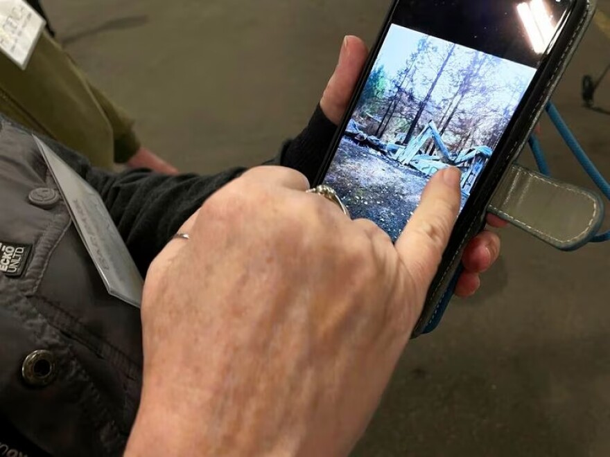 Barbara Benedict shows pictures of her home in Otis, Ore., which burned down in the Echo Mountain Complex fire. The 2020 Labor Day wildfires devastated southern Oregon and destroyed thousands of homes. Once completed, Barbara and Scott Benedict will be the first people to receive one of the mass timber affordable housing units that were on display, in prototype form, at the Port of Portland, in Portland, Ore. Friday, Jan. 27, 2023.