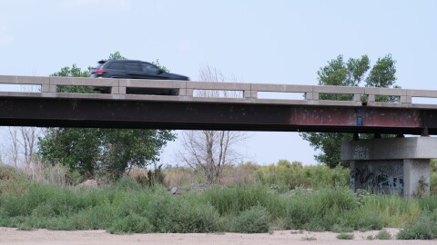 A car whizzes over the Arkansas River near Lakin, Kansas, where the river runs dry.