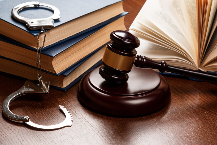 Gavel, books and handcuffs on wooden table