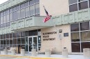 Front entrance to a building with large glass windows and signage on the front wall that reads 'Bloomington Police Department'