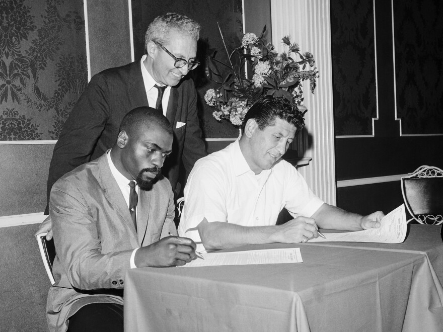 Middleweight champion Joey Giardello, right, signs a contract to defend his title against Rubin "Hurricane" Carter in Las Vegas in 1964 as Eddie Jaffe, the promoter of the fight, watches. Jaffe died in 2003.