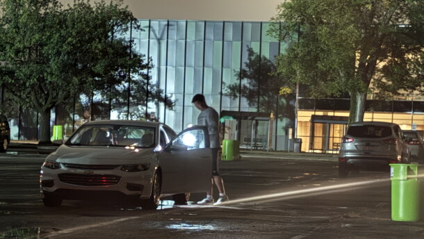 A person uses a flashlight near a vehicle on Michigan State University’s East Lansing campus during a widespread power outage Saturday night, Sept. 19, 2026.