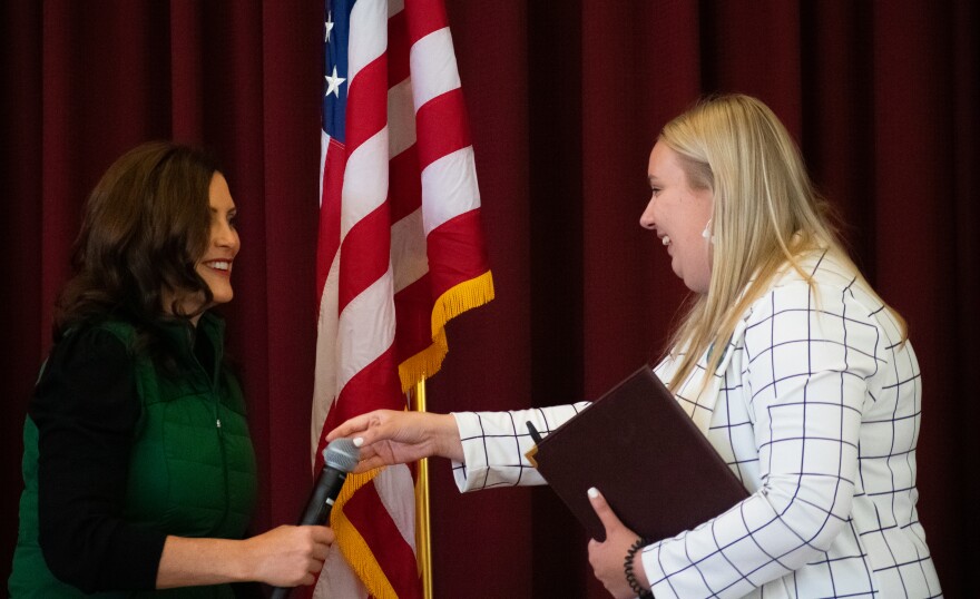 Student body Taylor Idema hands a microphone to Governor Gretchen Whitmer at a meet and greet event on Sunday, Oct. 9, in the Bovee University Center.