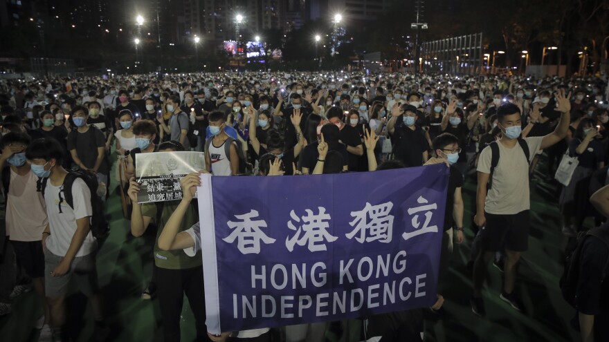 People attending a vigil for the victims of the 1989 Tiananmen Square massacre hold a banner reading "Hong Kong independence" at Victoria Park in Causeway Bay, Hong Kong, on Thursday. Official applications for the rally were denied.