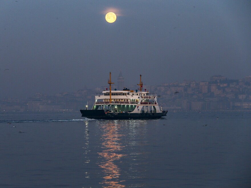 The full moon sets over the Bosphorus in Istanbul on Wednesday.