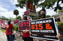 FILE - Workers and family members take part in a 15-city walkout to demand $15hr wages Wednesday, May 19, 2021, in front of a McDonald's restaurant in Sanford, Fla.
