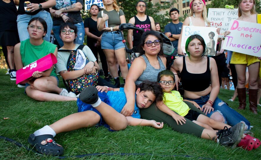 Gena Teran Flores and her three children— King, Divinity, and Zues— listen to speakers from the Afiya Center at Friday’s pro-choice protest in Dallas, Texas June 24. The importance of the Roe v. Wade decision lies in women's ability to decide if they're ready or not to have a child, Flores said.