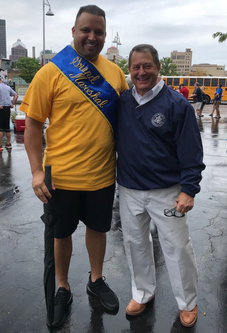 President of the International Association of Firefighters local 1071, Eddie Santiago wears his Grand Marshal sash alongside Democratic Congressman Joe Morelle.