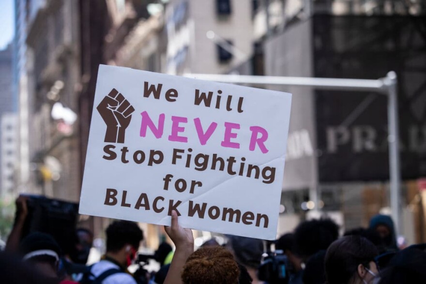A protester holds up their sign during a protest at Trump Tower in New York. (Ira L. Black/Corbis/Getty Images)