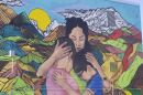 A mural depicting a mother holding two children is painted on the side of the Center for Immigrant and Refugee Advancement building in Omaha on Dec. 5, 2025. The artwork reflects themes of family separation and protection central to many immigration cases.