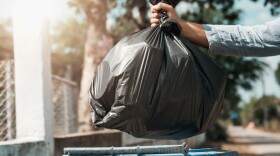woman hand holding garbage black bag put in to trash