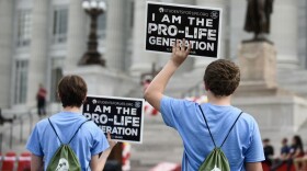 Students hold up anti-abortion signs at the Midwest March for Life on Wednesday at the Missouri State Capitol.