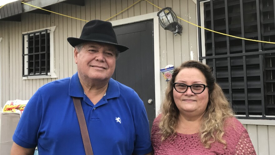 Irma Rivera Aviles and her husband, Ivan Martínez, stand in front of their home last month. Rivera Aviles was ecstatic about the restoration of power to her neighborhood last Friday.
