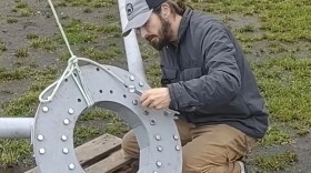 a man assembles a tent fram outside