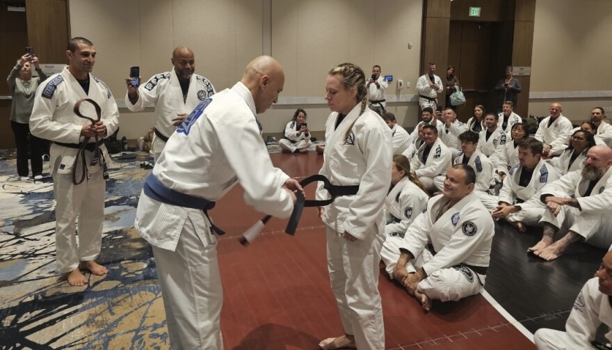 Michelle Cassady receiving her Royce Gracie black belt from Royce Gracie.