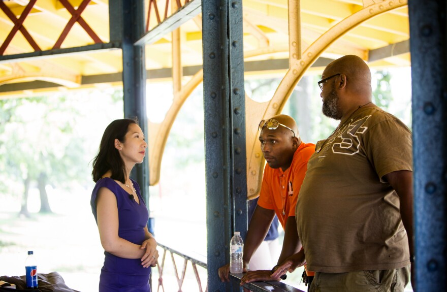 Leana Wen talks with Safe Streets outreach workers Dante Barksdale and Gardnel Carter in Druid Hill Park in Baltimore.