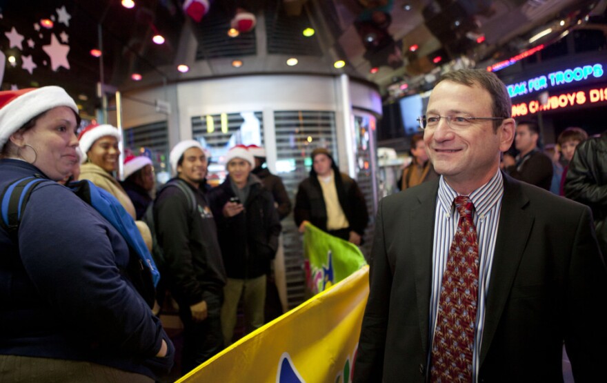 Gerald L. Storch, CEO and chairman of Toys R Us, speaks with customers waiting in line outside the company's store in Times Square in New York on Thanksgiving.