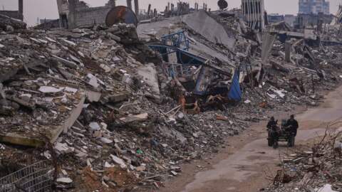Palestinians pass along a street surrounded by buildings destroyed during Israeli air and ground operations in the Sheikh Radwan neighborhood, in Gaza City, Tuesday, Dec. 30, 2025. (Abdel Kareem Hana/AP)