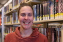 Tonya Ellis wears an orange cowl-neck sweater and smiles into the camera. 