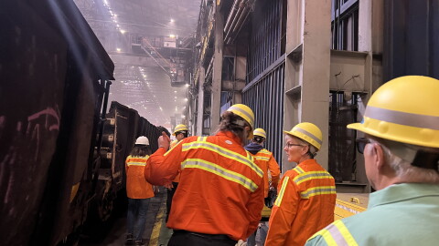 Visitors and staff dressed in orange safety equipment tour the Cleveland-Cliffs steel mill with the U.S. Secretary of Energy, Jennifer M. Granholm.