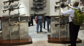 A convention attendee looks through a display of Sig Sauer semiautomatic rifles during the 35th annual SHOT Show, Tuesday, Jan. 15, 2013, in Las Vegas. (Julie Jacobson/AP)
