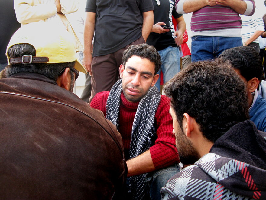Hassan Issa grieves for his father, Issa  Abdel Hassan, who was killed Thursday morning. "I was supposed to be the martyr, not  him," the son said. He said they had been making their way to  Pearl Square, where police had charged in with tear gas, clubs and other  weapons, when his father was shot by police.
