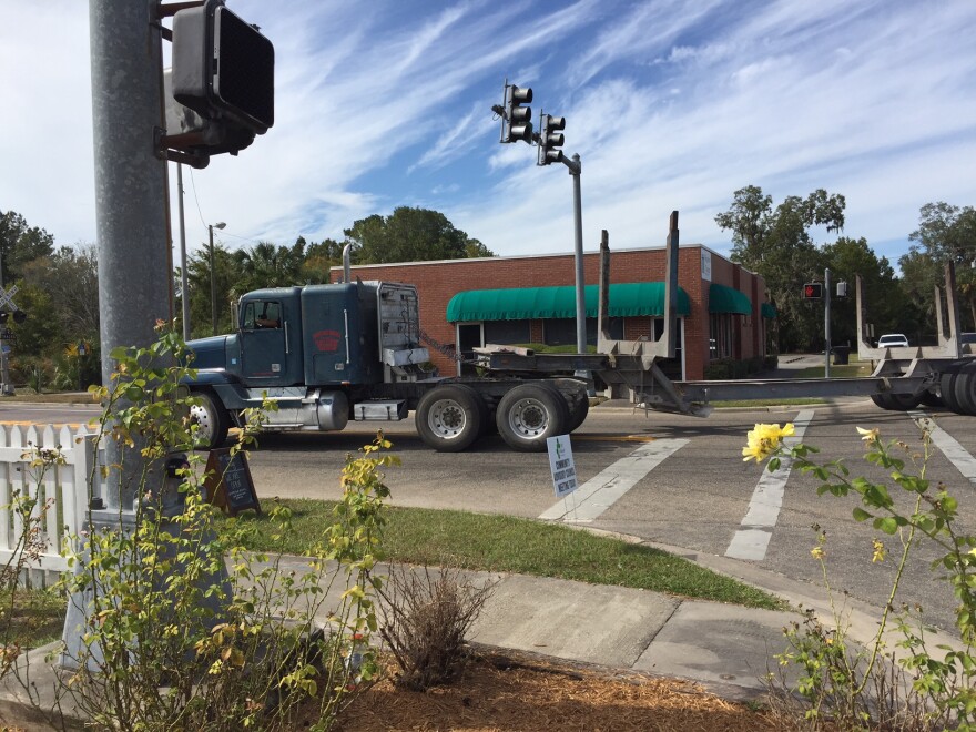 A logging truck rolls through downtown Perry.