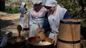 Emma Dodd and Claire Quinn, churn butter at  Claude Moore Colonial Farm.