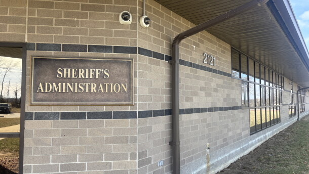 Exterior of Boone County Sheriff's administrative building. A mounted placard with gold lettering on a beige brick wall reads "Sheriff's Administration," with the address number 2121 displayed on the wall to the right of the placard.  