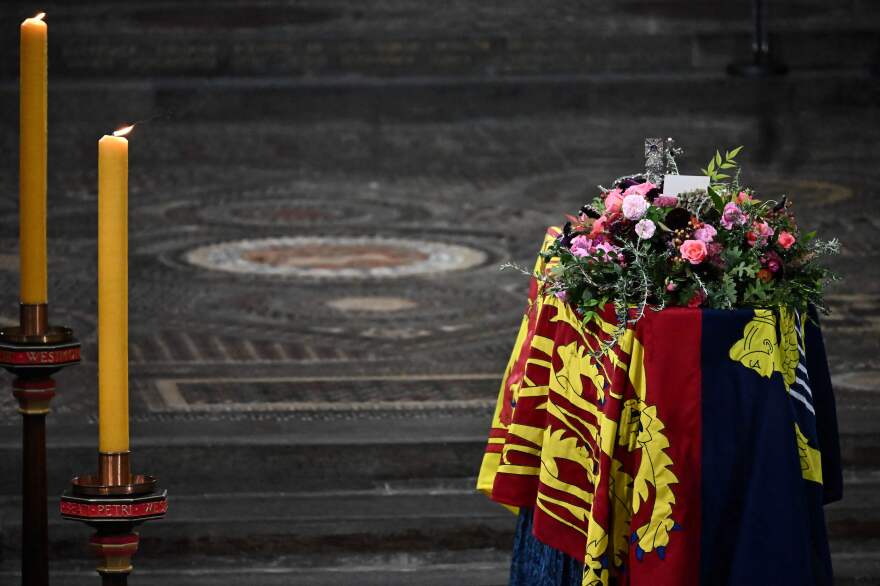 The coffin of Queen Elizabeth II, draped in the Royal Standard, lies inside Westminster Abbey.