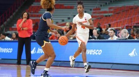 Teisha Hyman (with basketball) takes up the basketball in a Syracuse women’s basketball game against Coppin State, with first year head coach Felisha Legette-Jack looking on.