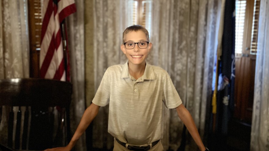 Peter Gestwicki, winner of presidential contest, stands behind President Benjamin Harrison's desk.