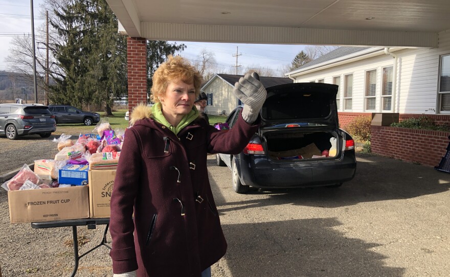 CHOP volunteer, Tammy Lockhart waves the next vehicle through the line at the Pop Up Pantry in Sayre, Pa.