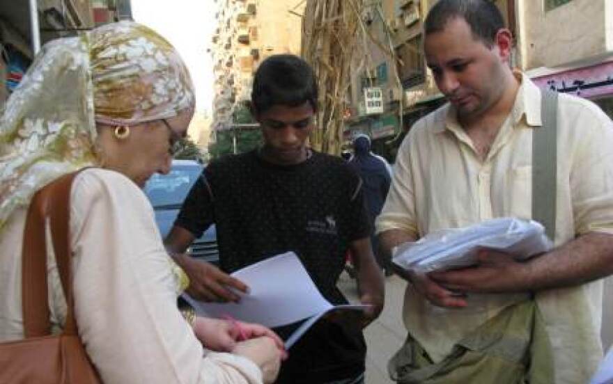 From The Web To The Streets: Ahmed Nasser (right) and Shahinaz Abdel-Wahab hand out petitions for better governance in the Mahdi neighborhood in Cairo. They are part of the April 6th movement, political activists who started as an Egyptian Facebook group.