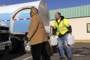 Adam Guay carries jugs of water for Theresa Slayton from a tank truck at Southside Plaza in Richmond, Va., Thursday, Jan. 9, 2025, as the city recovers from a water outage after a winter storm.