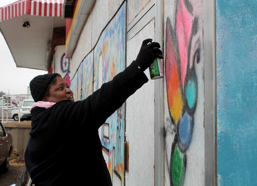 Adrienne Hawkins adds pink to a wing of her butterfly.