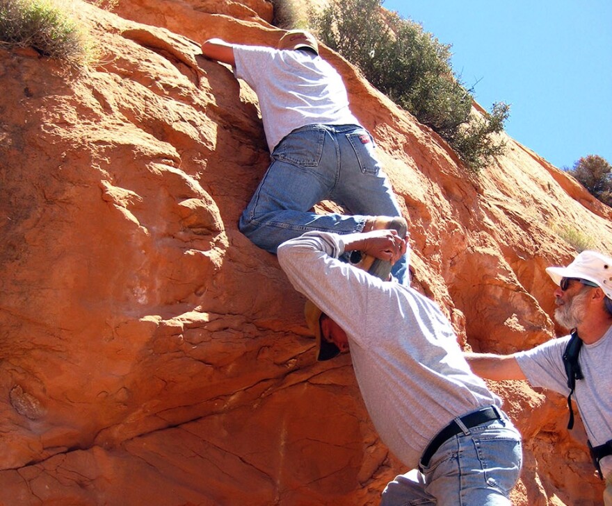Navigating ancient handholds to reach a rock art site on the Navajo Nation.
