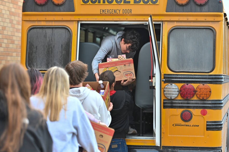 Forest City classmates hand Jacob Conlogue, a junior, boxes of food to be delivered.