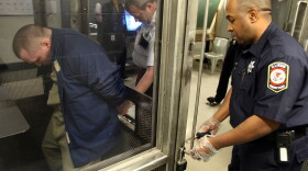 Lt. Robert DuBois (center) handcuffs Tamms Correctional Center inmate Damien Terry (left) before he is taken from his holding cell in 2009. State budget constraints are forcing the facility — Illinois' only supermaximum security prison — to either close or be converted to a lower-security prison.