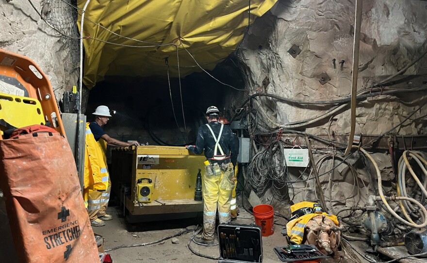 Pinyon Plain Mine Assistant Superintendent Matt Germansen talks to electricians working in one of the mine's many tunnels.