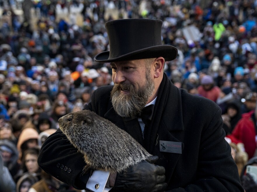 Groundhog handler AJ Derume stands in front of a crowd holding Punxsutawney Phil, who saw his shadow on Thursday to predict a late spring.