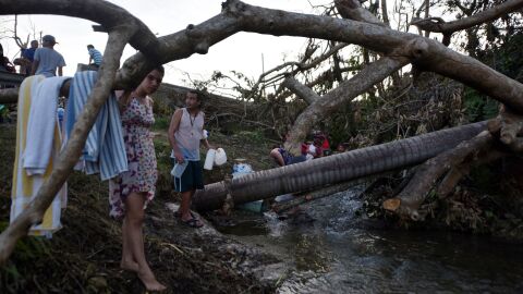 People carry water in bottles retrieved from a canal due to lack of water after Hurricane Maria, in Toa Alta, Puerto Rico, on Monday.