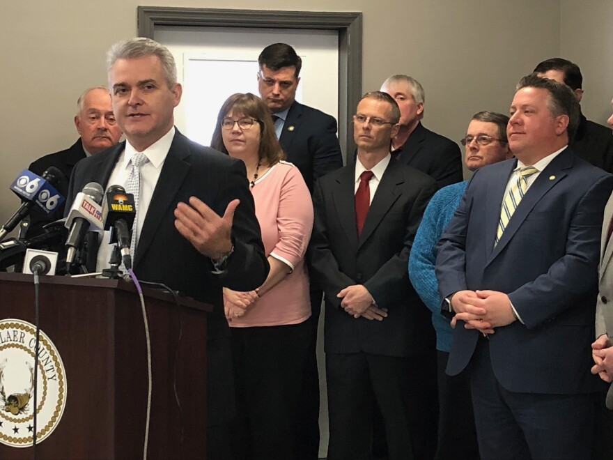 Rensselaer County Executive Steve McLaughlin (at the posium) as Albany County Executive Dan McCoy and other officials look on.