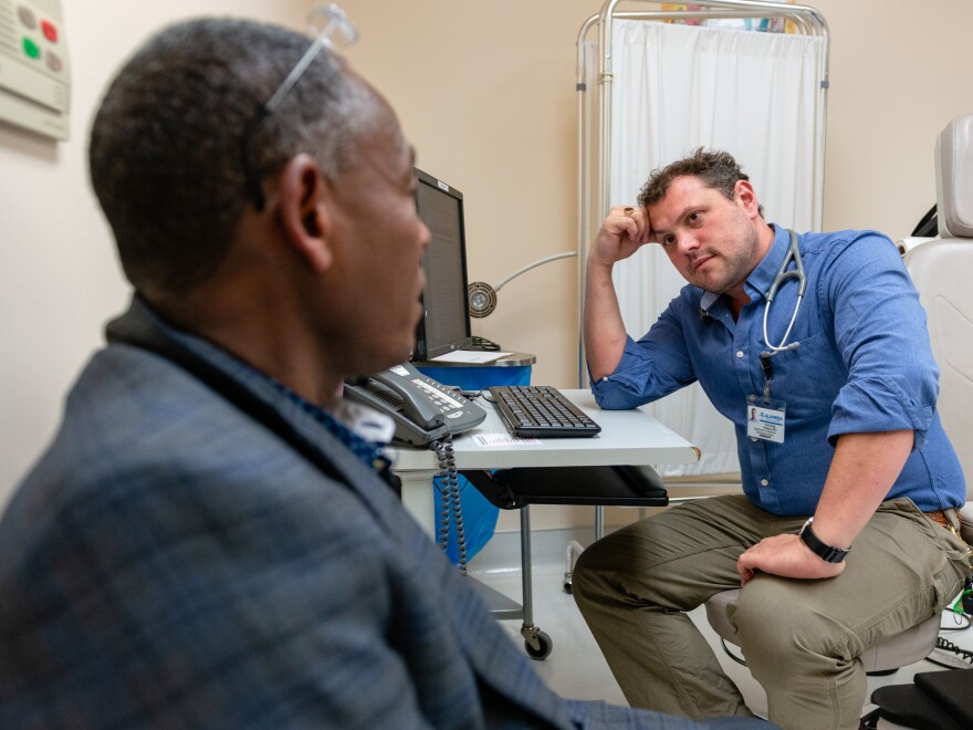 Gebremeskl Tefamicael (left), an asylum-seeker from Eritrea, bears deep scars on his wrists. He explains to Dr. Nick Nelson that he was imprisoned and tortured by soldiers in Eritrea who used rope made from tree bark to restrain him.