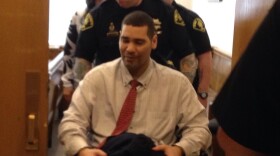 Guards wheel Monfort from the courtroom on Wednesday. Monfort is paralyzed from the waist down.