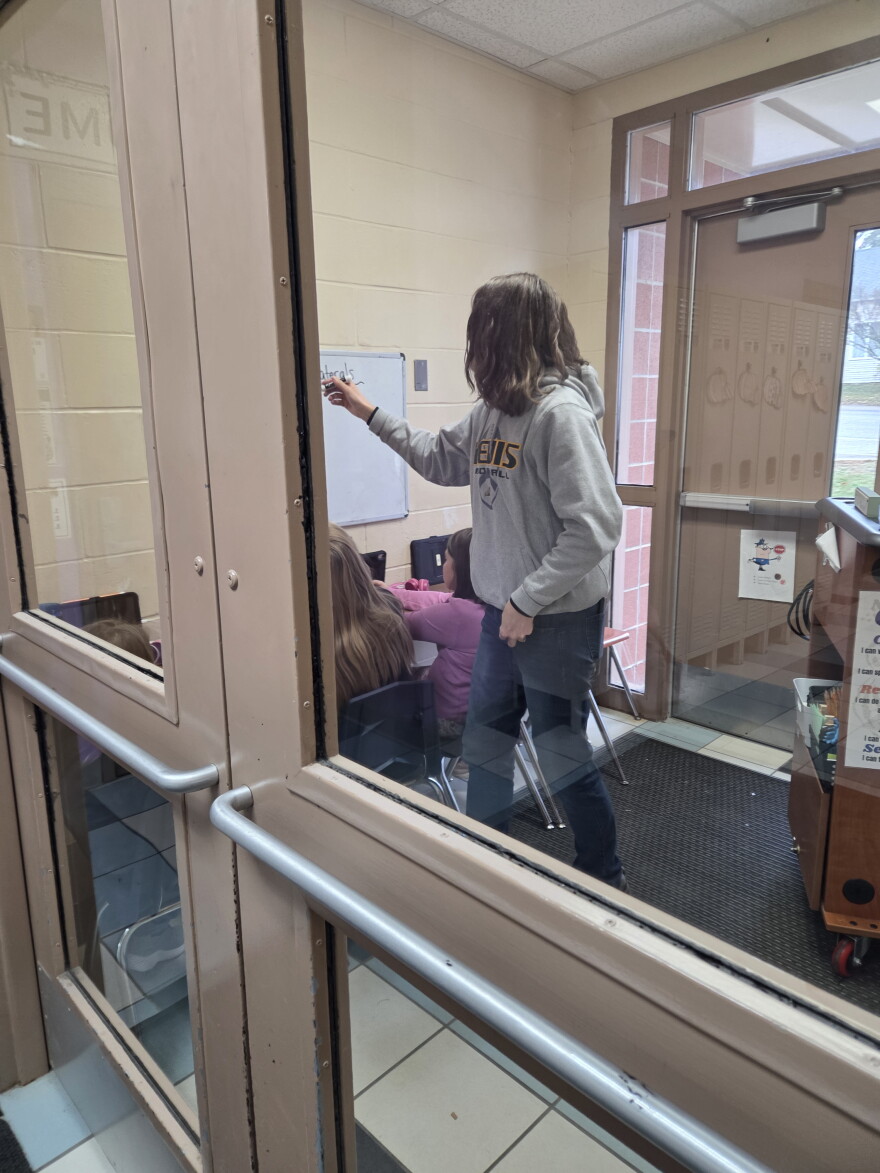 A Nevis teacher works with three students in a vestibule near the elementary wing on Oct. 27, 2026.