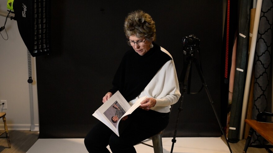 Barbara Pennington looks at her book, Extraordinary Woman From An Ordinary Place, in her home studio in Boston Heights.